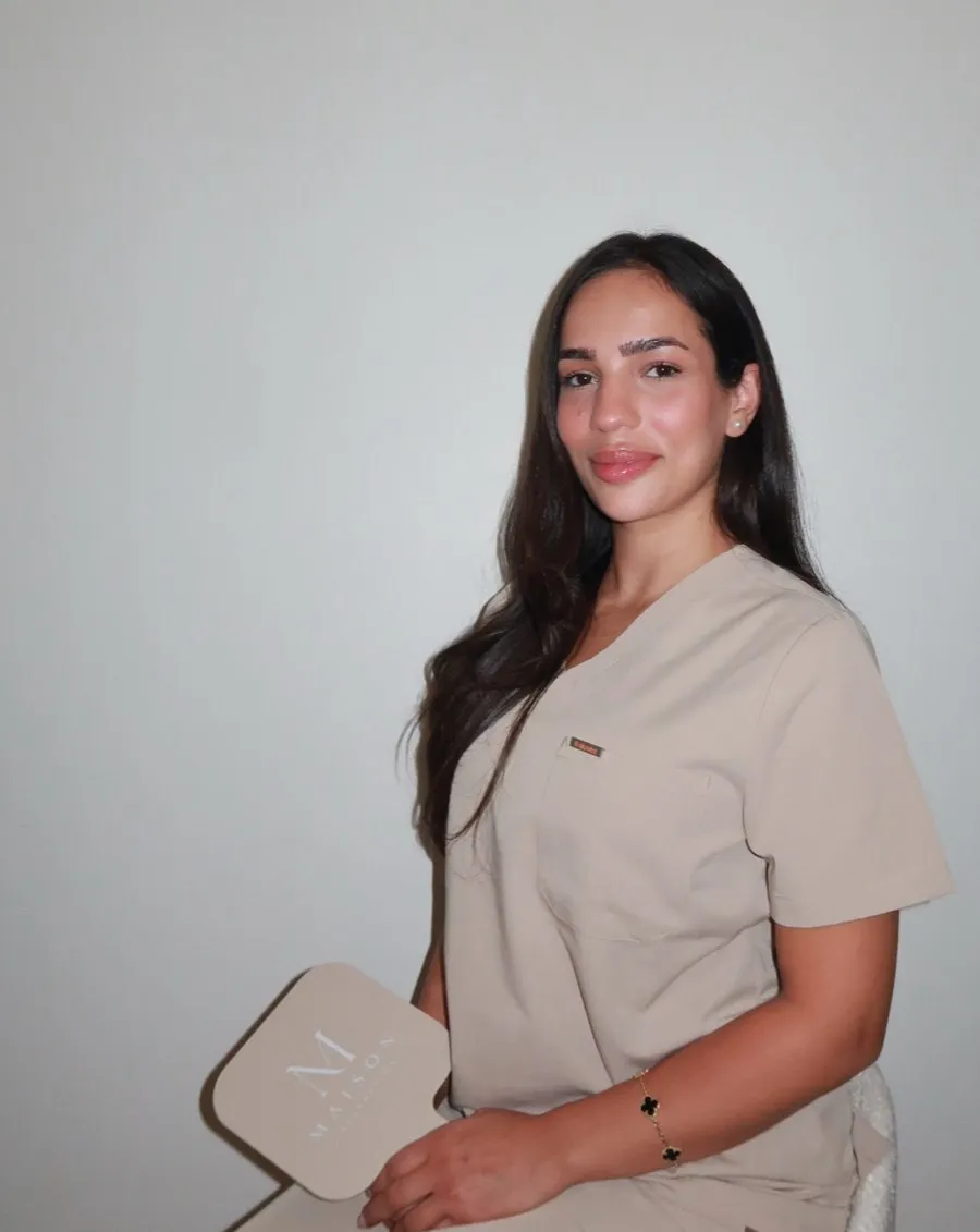 Dilan Bozdag, partner and skin specialist, holding a Maison hand mirror